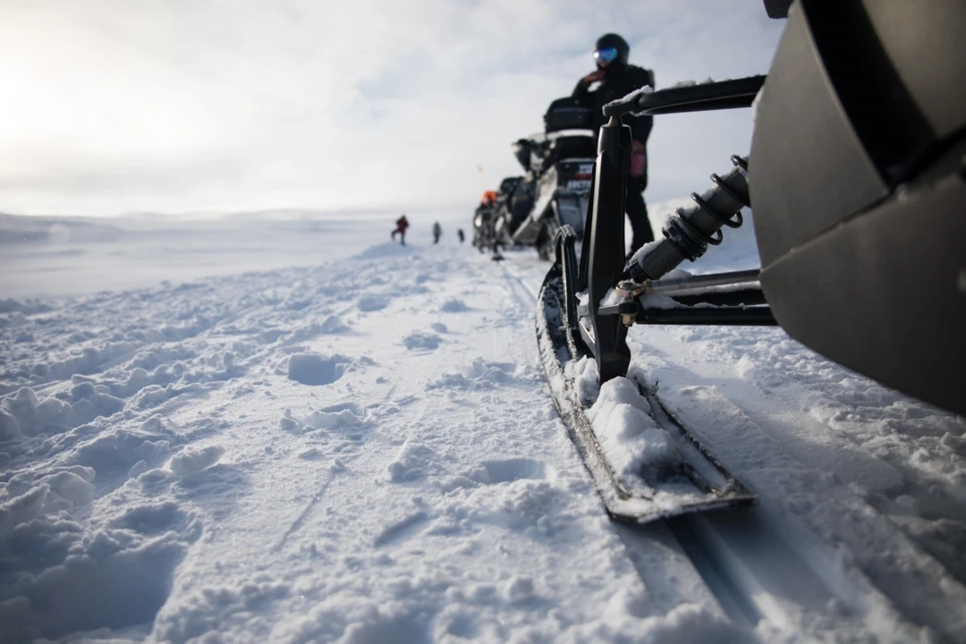 Snowmobiles riding on a snowy trail, representing a well-maintained machine ready for winter in Sherbrooke.