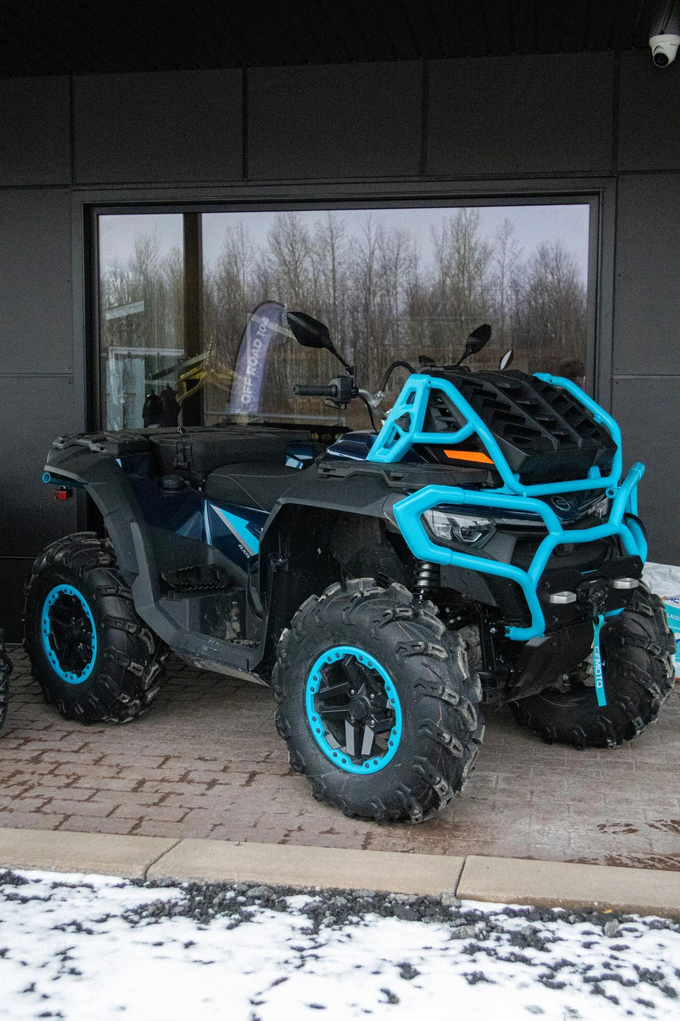 VTT CFMOTO CFORCE 1000 avec pare-chocs avant renforcé et pneus tout-terrain, stationné à l’extérieur en hiver