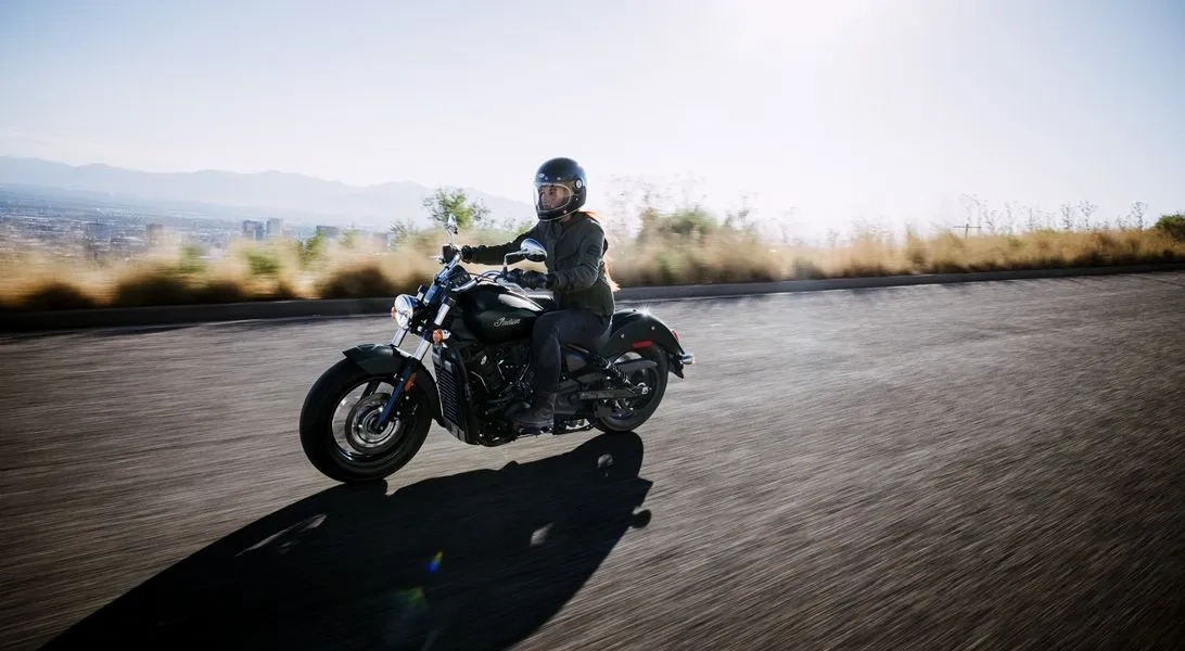 Moto Indian Scout Sixty en conduite sur route, symbole de confort et de puissance.