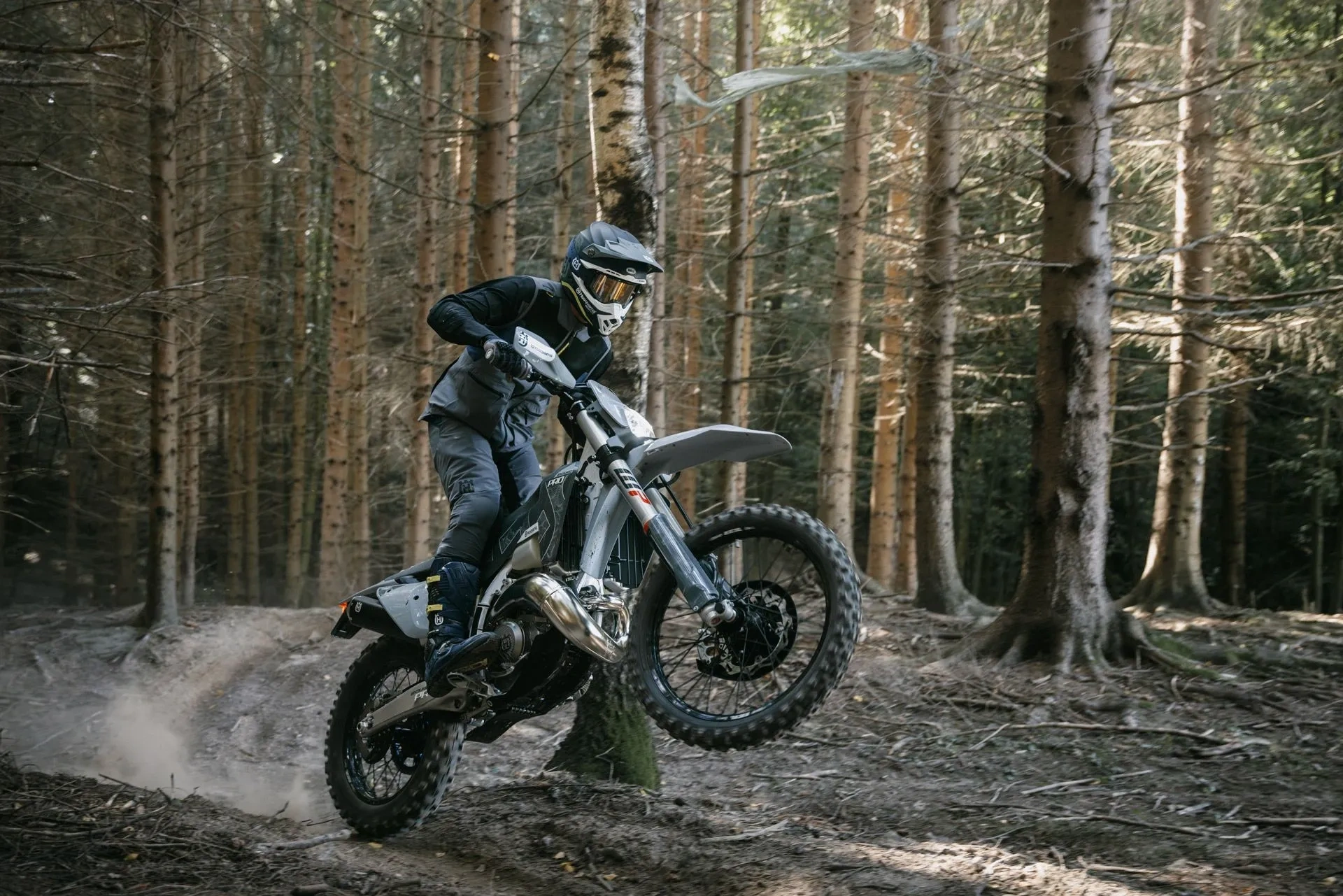 Husqvarna Enduro TE 300 Pro en sentier forestier, une moto distinctive conçue pour le hors-route.