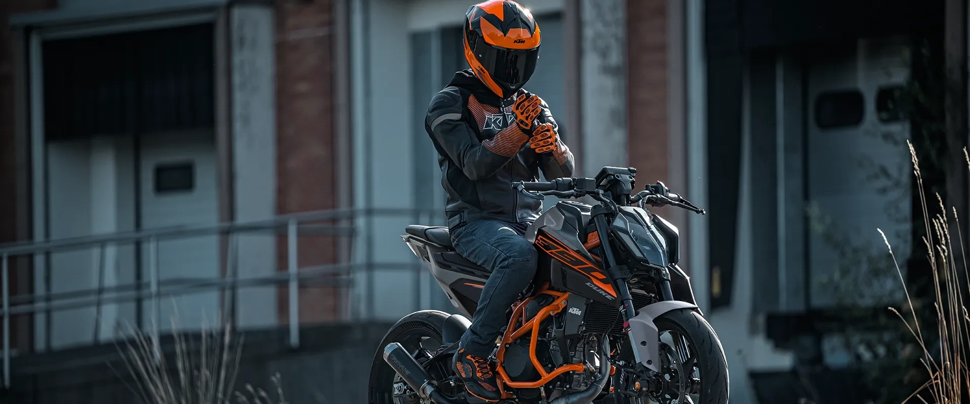 KTM Duke 390 noire et orange avec motocycliste en milieu urbain.