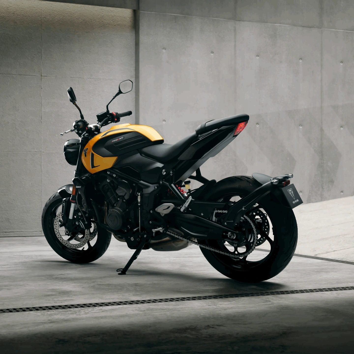 Triumph Trident 660 jaune vue arrière dans un environnement urbain.