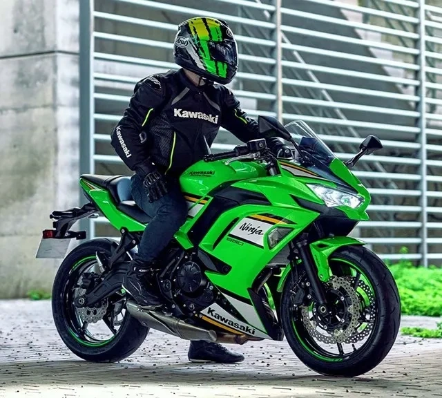 Kawasaki Ninja 650 verte stationnée avec un motocycliste.