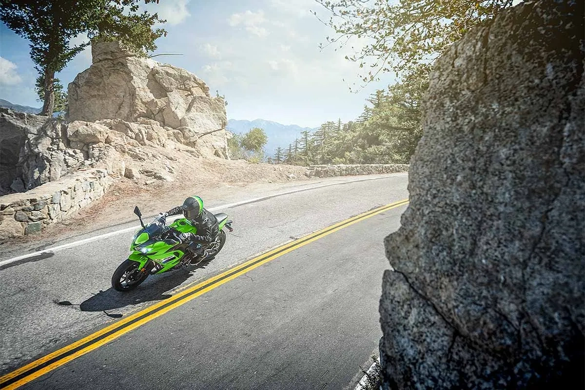 Kawasaki Ninja 650cc verte sur une route de montagne sinueuse.