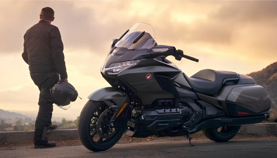 Honda Gold Wing 2026 grise stationnée devant un paysage au coucher du soleil.
