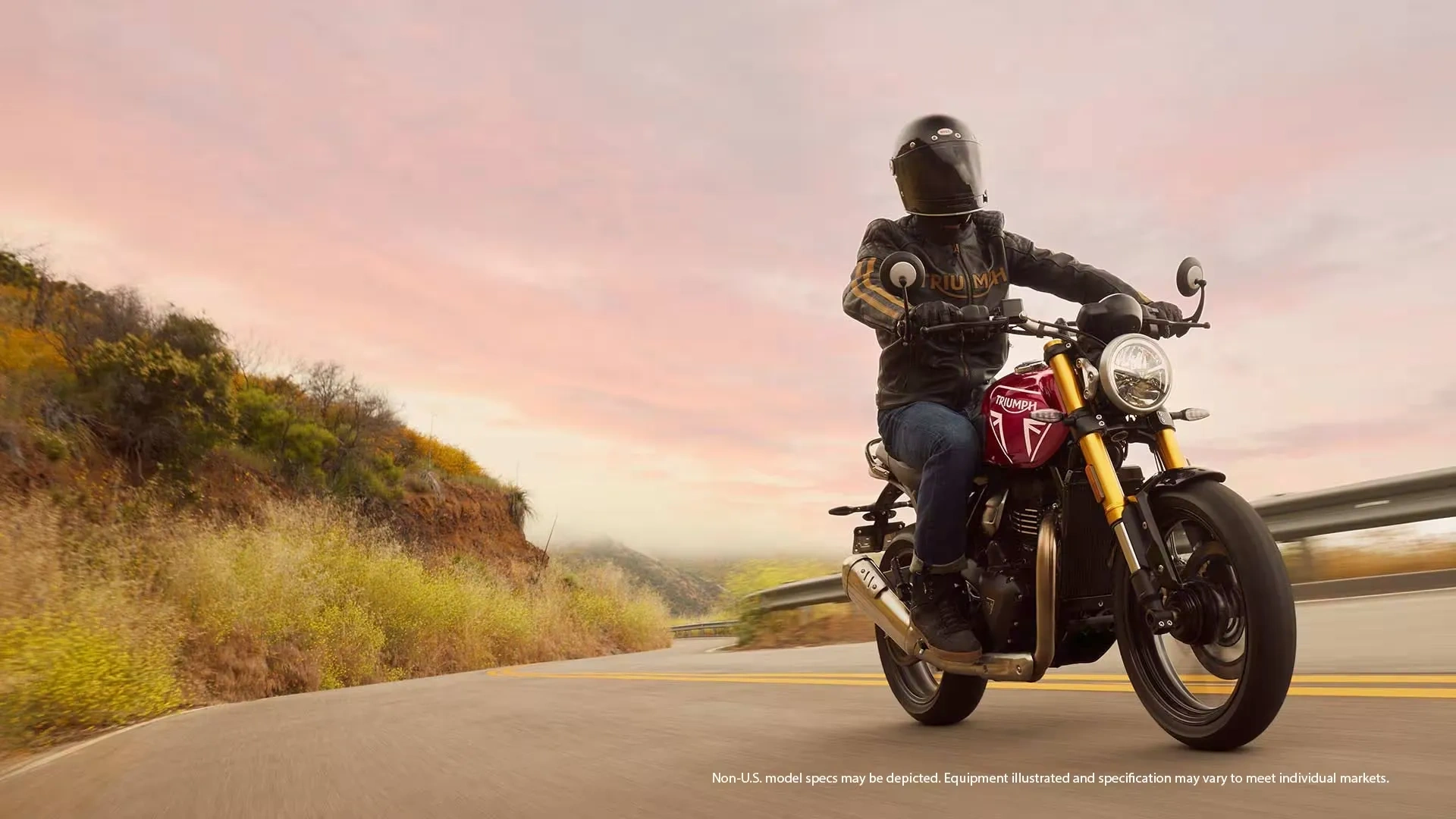 Triumph Speed 400 rouge en randonnée sur une route au coucher du soleil.