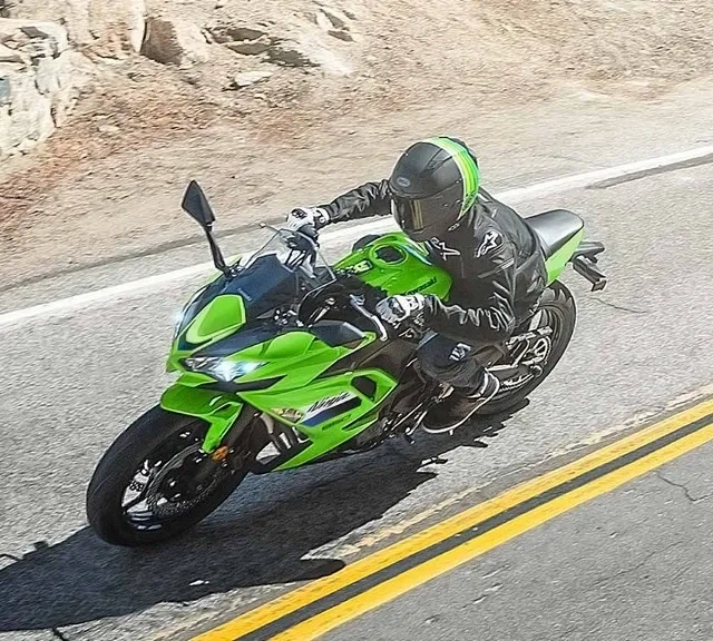 Kawasaki Ninja 650 verte sur une route, vue en plongée.