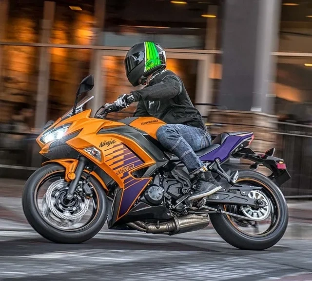 Kawasaki Ninja 650 orange en déplacement dans la ville.