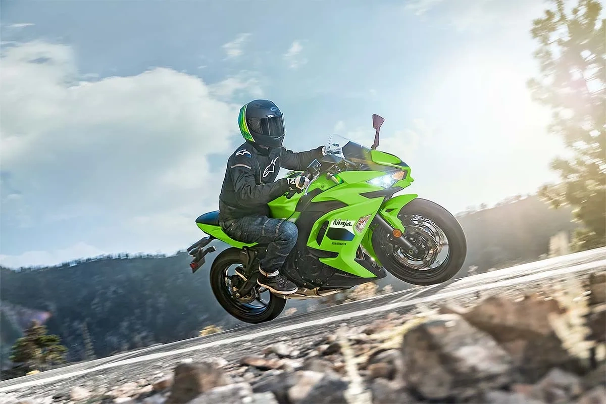 Kawasaki Ninja 650cc verte en conduite sportive sur une route panoramique.