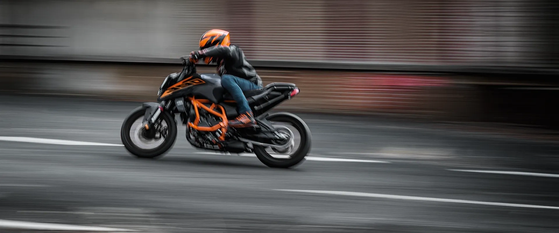 KTM Duke 390 noire et orange en conduite dynamique sur la route.