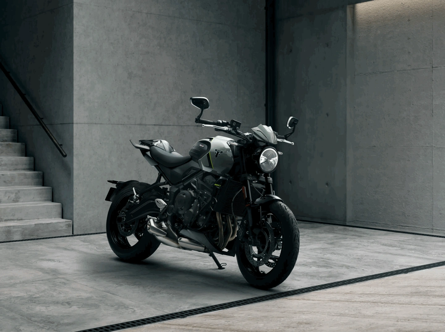 Triumph Trident 660 noire stationnée dans un décor moderne en béton.