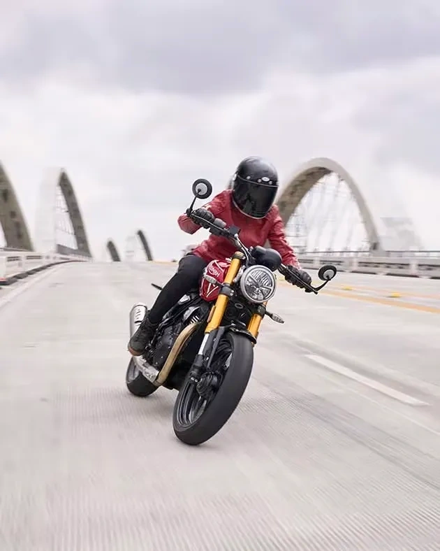 Triumph Speed 400 rouge prise de face pendant une conduite sportive.