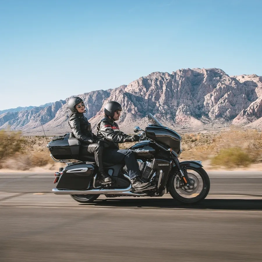 Indian Roadmaster PowerPlus 112 avec pilote et passagère sur une route de montagne.