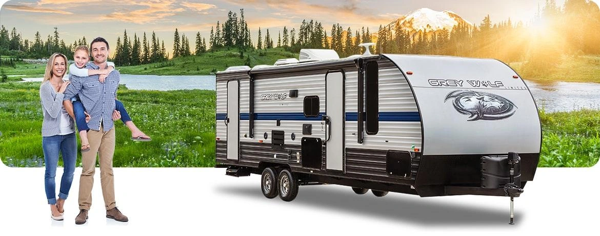 Family with RV trailer in mountain landscape