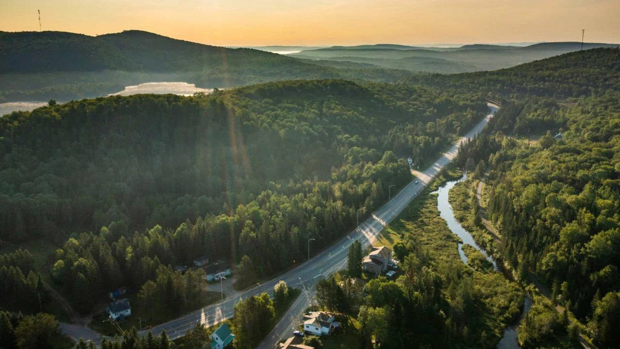 Route sinueuse traversant une forêt dense dans les Laurentides