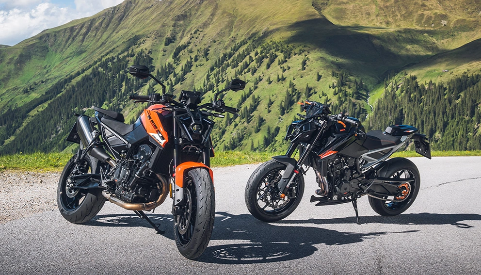 View of two 2027 KTM 790 motorcycles on the road in summer