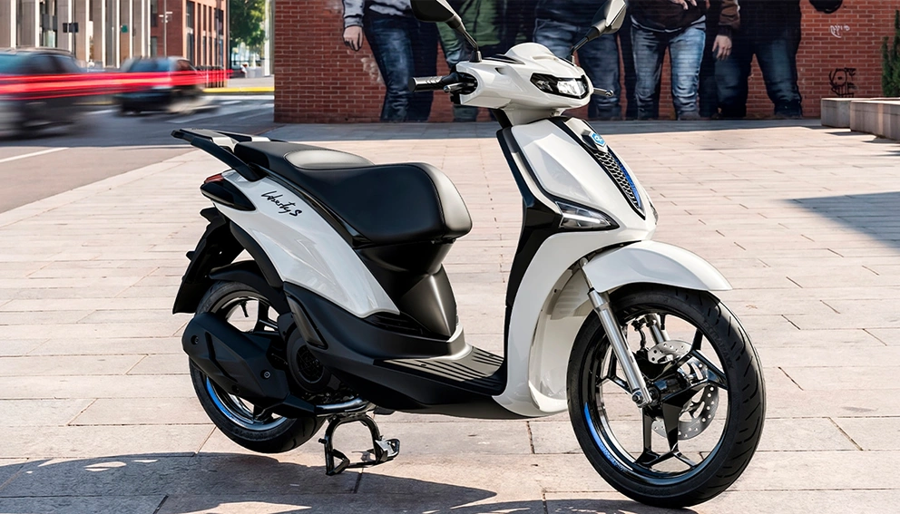 Vue de la Piaggio Liberty 50 en arrêt en bord de rue pavé