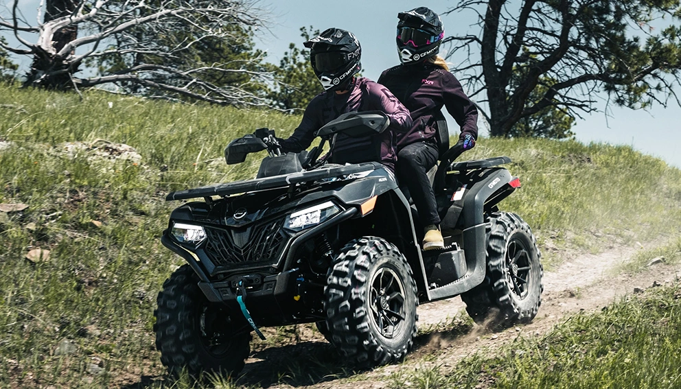 View of the CFMOTO CFORCE 600 Touring on the road in a field
