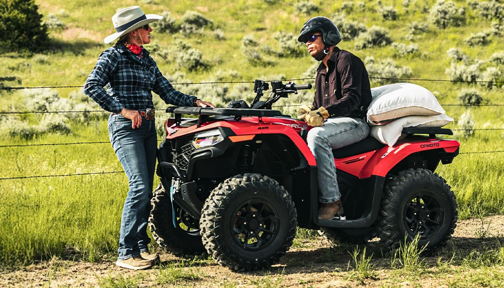 View of the CFMOTO CFORCE 500 parked in a field, with a cowgirl