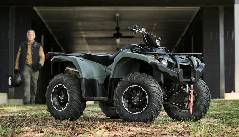 A view of the Yamaha Kodiak 450 parked and a man getting ready to go mountain biking