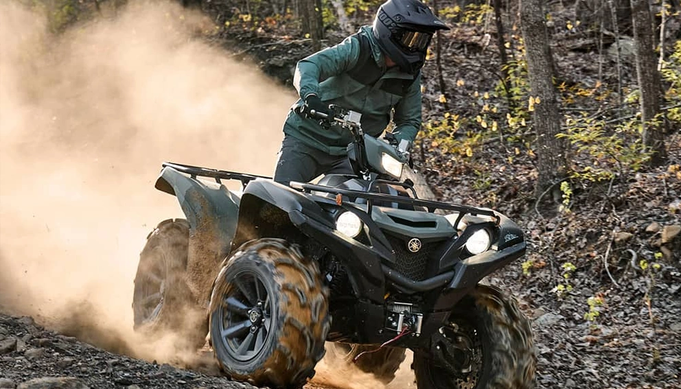 A view of the Yamaha Grizzly DAE XT-R in full power on a rocky forest trail