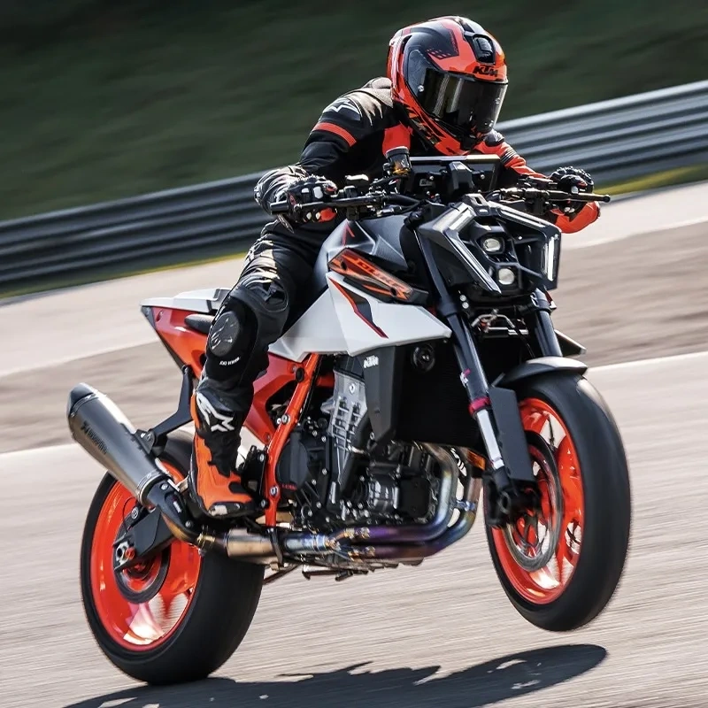 KTM 990 Duke orange en conduite sur une piste, effet de mouvement.
