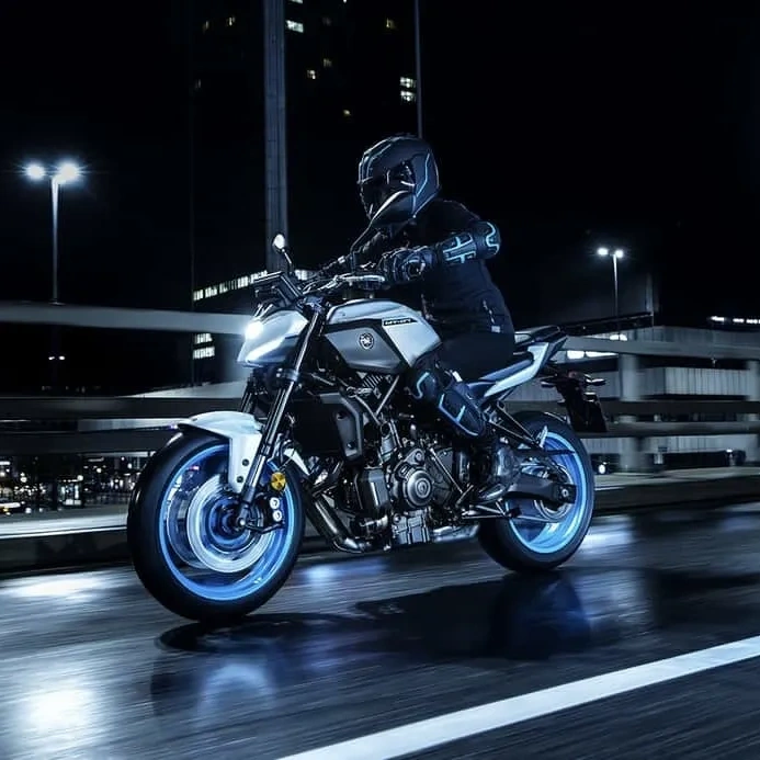 Yamaha MT-07 noire garée de nuit avec éclairage bleu.