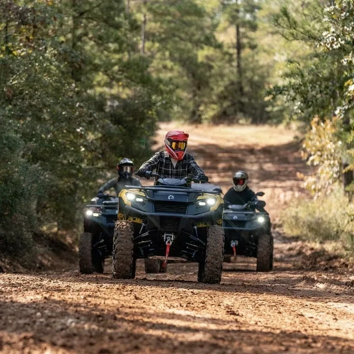 Can-Am Outlander 500 en conduite sur un sentier forestier.