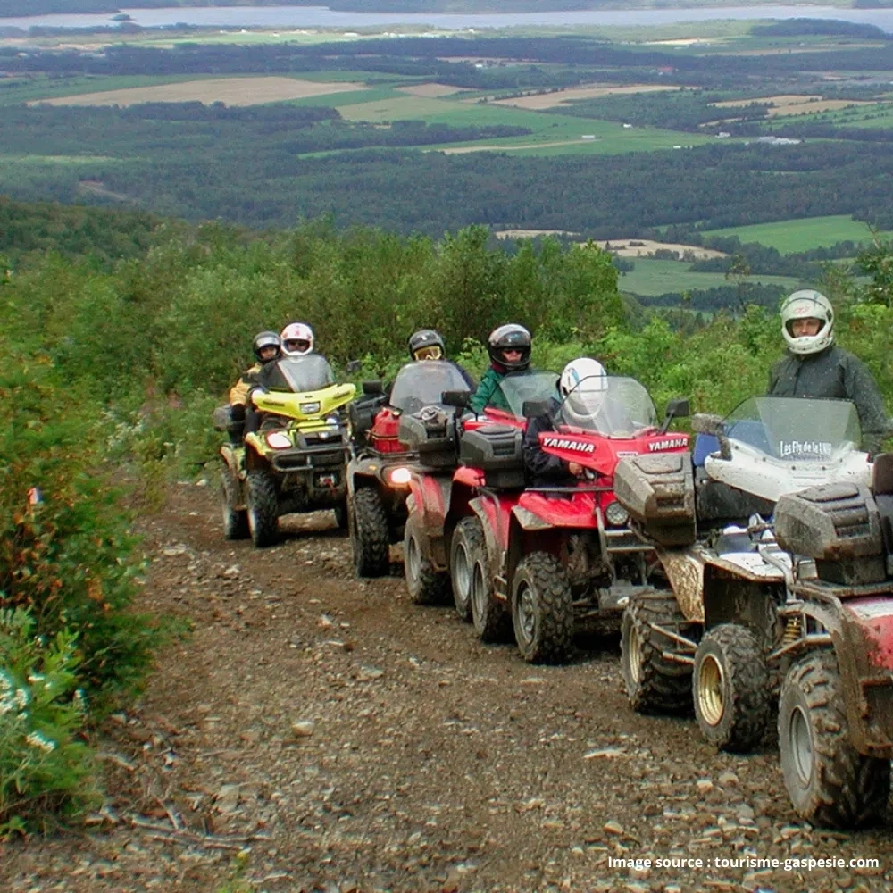 File de VTT en conduite près d'un lac dans les circuits de la Gaspésie.