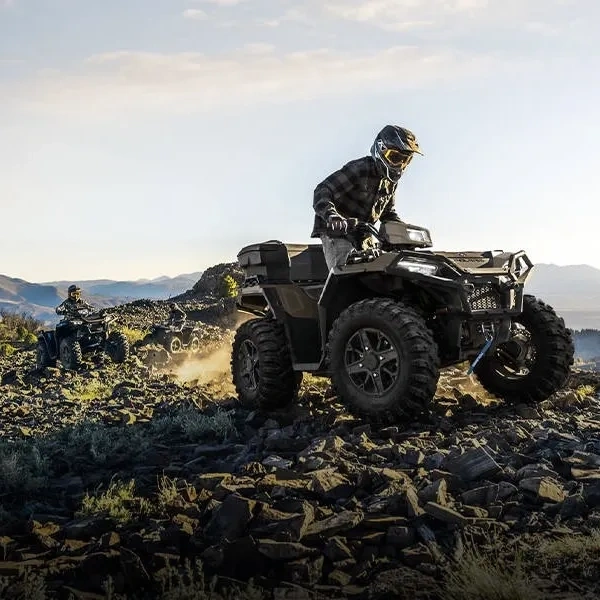 Polaris Sportsman 570 garé près d'un point d'eau au crépuscule.