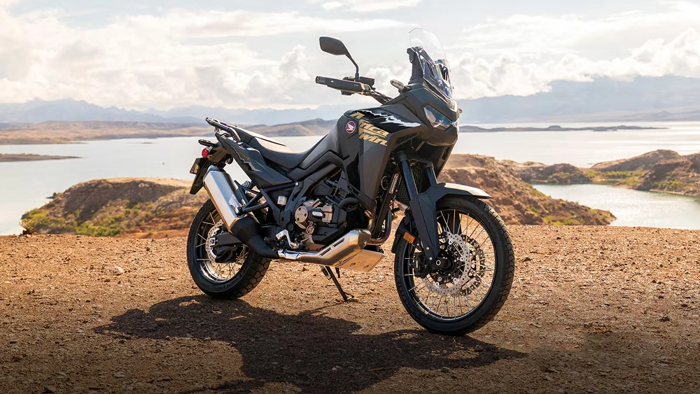 Vue d'une moto Honda Africa Twin Adventure Sports 2026 en arrêt sur colline de sable avec vue sur mer