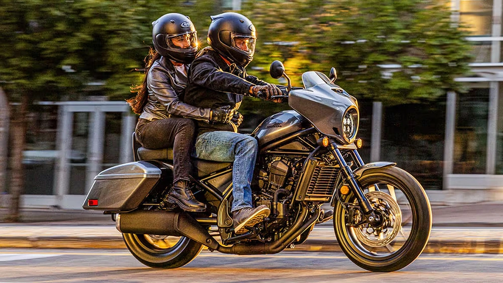 Vue d'un couple sur un Honda Rebel 1100T 2026 sur route en ville