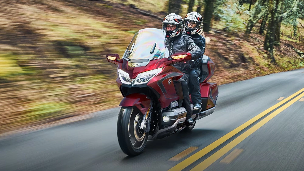 Vue d'un couple sur une Honda H26 Touring sur route en pleine puissance