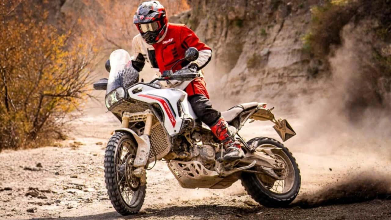 Ducati DesertX adventure motorcycle riding on a dirt trail