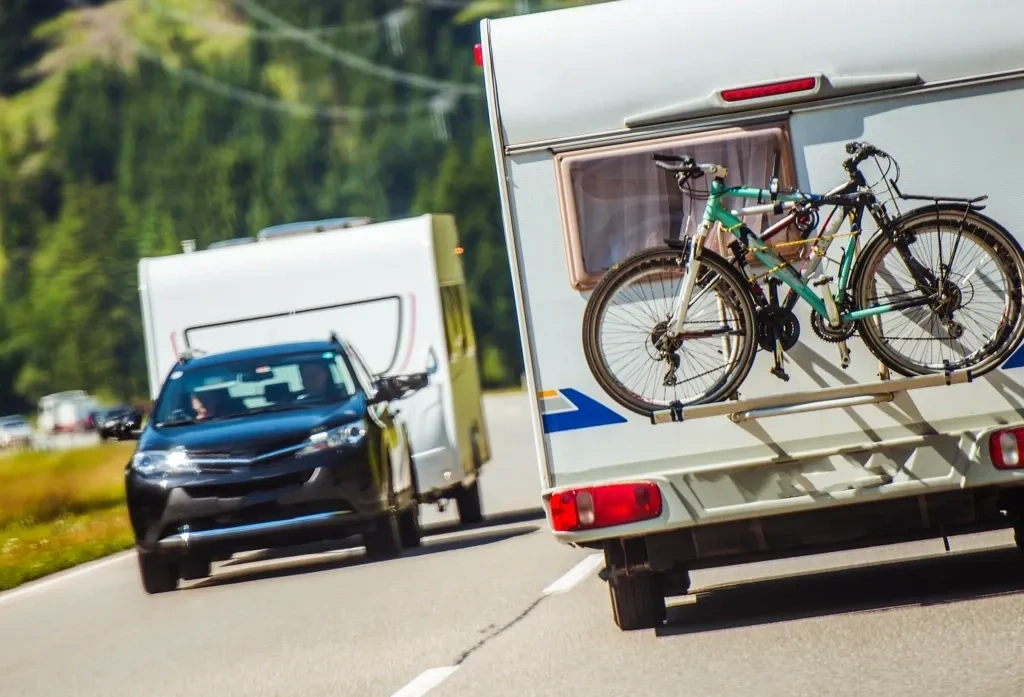 Roulotte en circulation avec vélos fixés à l’arrière, illustrant l’adaptation du modèle aux besoins réels, aux loisirs et à l’usage prévu.