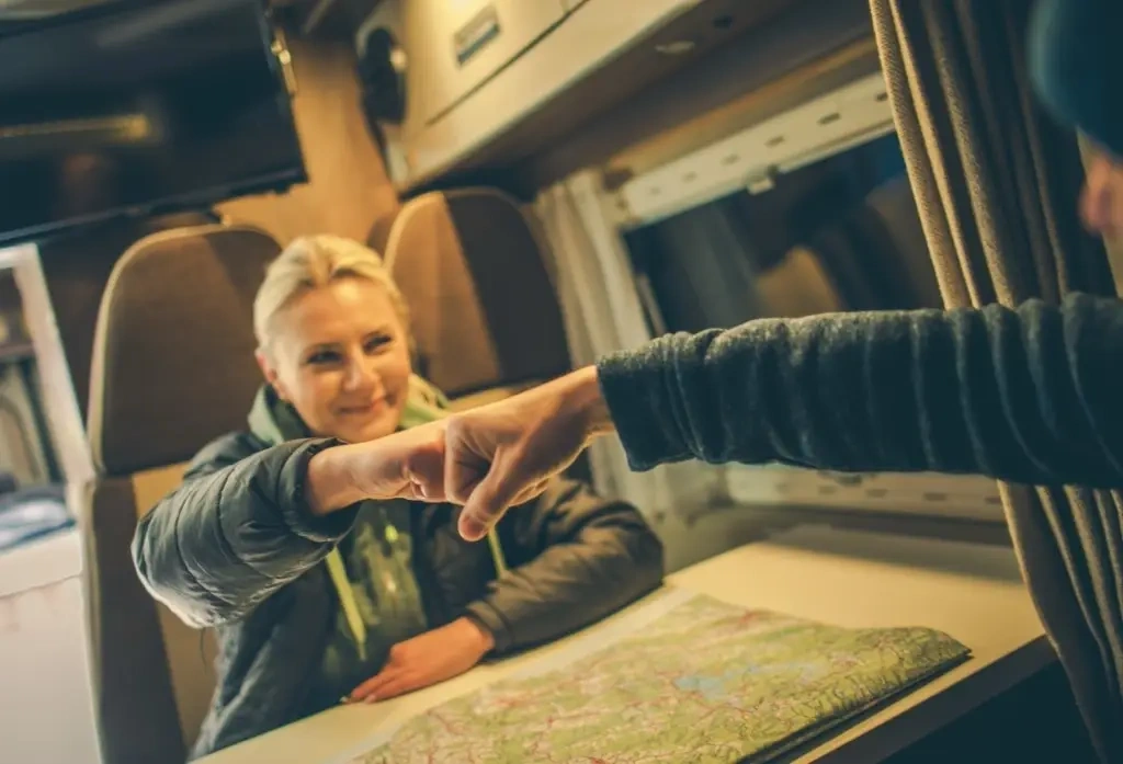 Deux amis voyageurs se donnant le coup de poing-à-poing et explorant une map afin de planifier leur trajet en VR