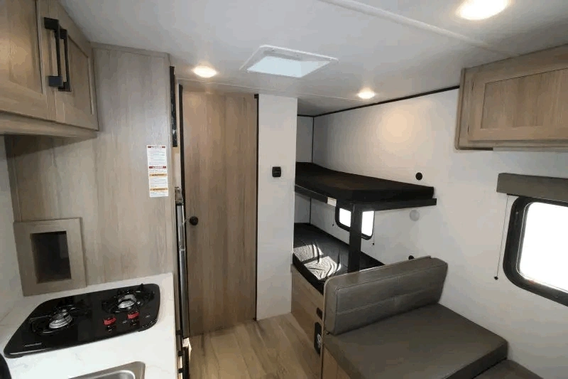 Intérieur du Coleman 17B avec lits superposés et cuisine.