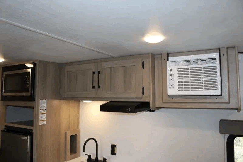 Climatiseur et armoires de cuisine dans la roulotte Coleman 17R.