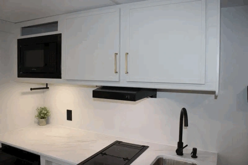 Armoires blanches et micro-ondes dans la cuisine du Transcend One 151RB.