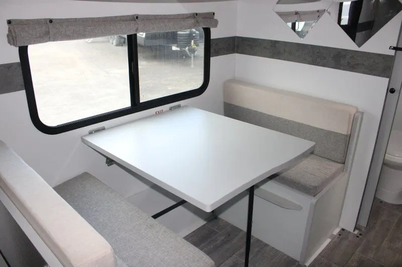 Dinette de la Nova Camp 201QB avec banquettes et grande fenêtre.