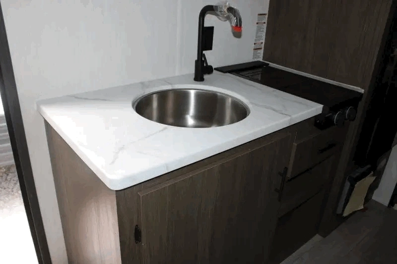 Cuisine du Prime Time Avenger LT 16BHX avec évier rond et comptoir compact.