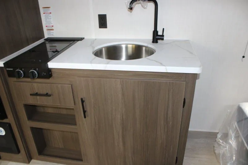 Cuisine du Prime Time Avenger LT 16RBX avec évier et plaque de cuisson.