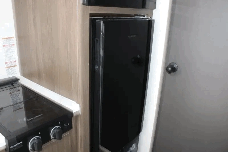 Réfrigérateur noir du Prime Time Avenger LT 16BHX près de la cuisine.