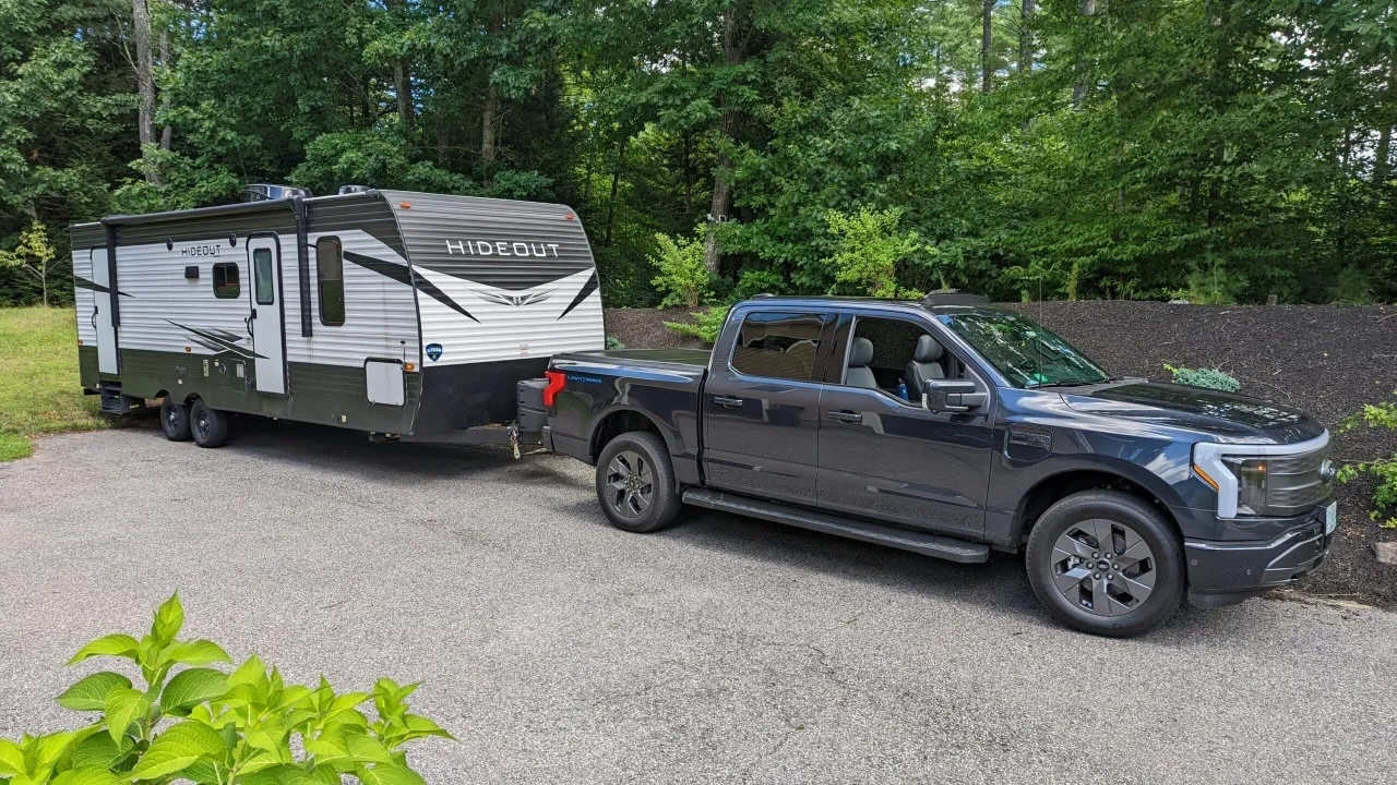 Vue de trois-quarts d'un Ford F-150 en plein remorquage sur une route asphaltée