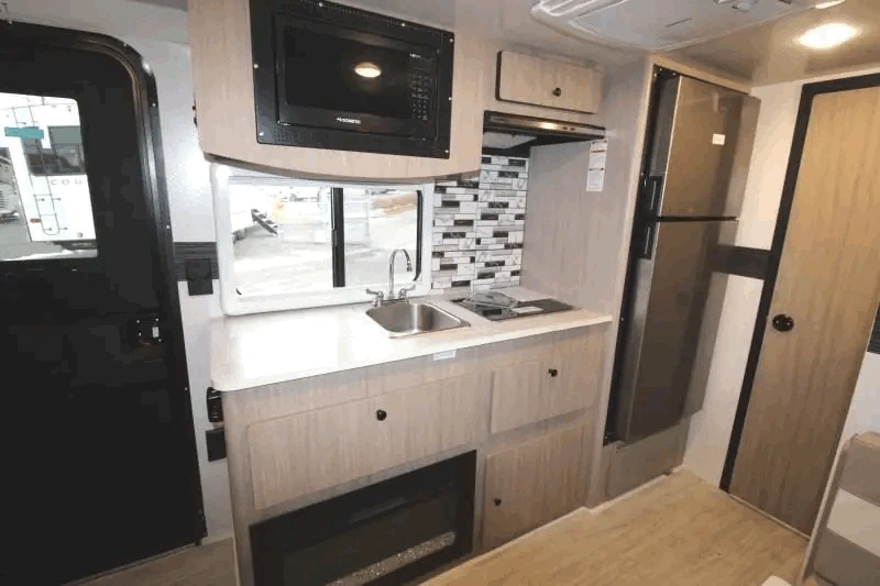 Cuisine de la Nova Camp 201BH avec évier, réfrigérateur et micro-ondes.