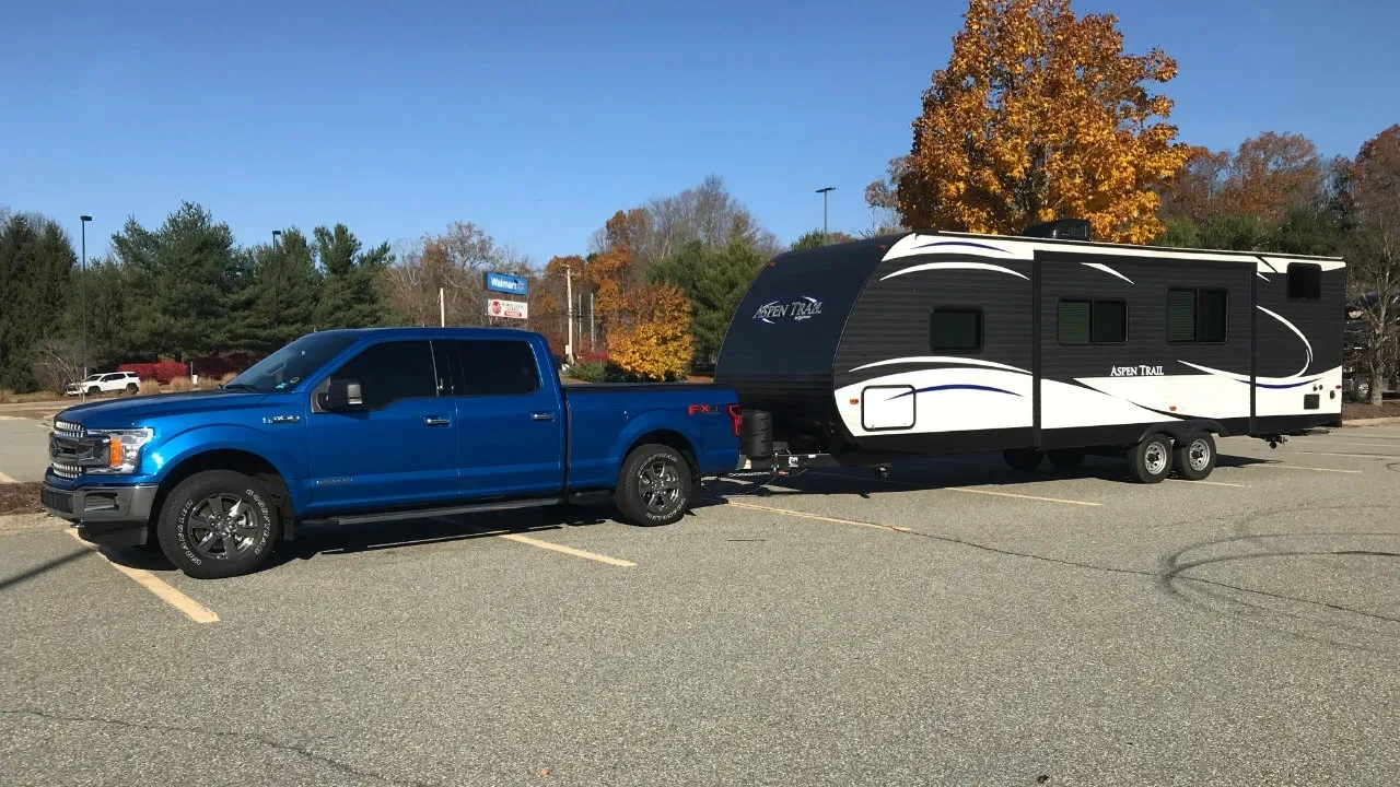 Ford F-150 stationné en compagnie d'une roulotte de camping attelée
