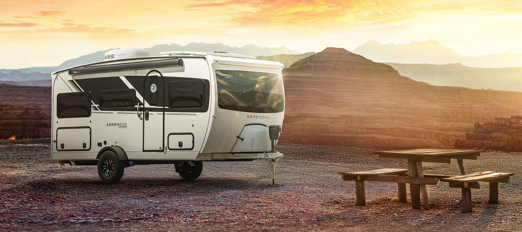 Roulotte moderne installée dans un paysage désertique avec espace extérieur aménagé, représentant les nouvelles tendances de vie extérieure en 2026.
