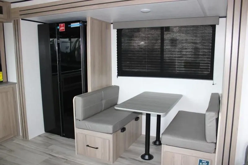 Dinette de la Coleman Lantern 25REX avec banquettes et grande fenêtre.