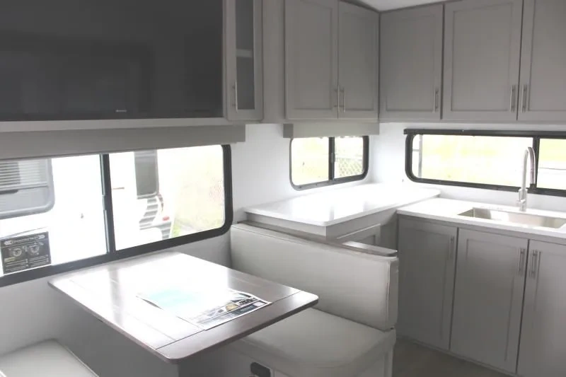 Coin repas et cuisine du Alliance Avenue All-Access 23ML avec dinette, banquette, comptoir, évier et armoires grises.