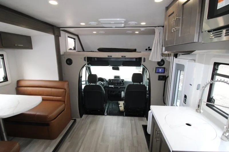 Intérieur du Dynamax Isata 3 24RW avec cuisine et vue vers la cabine.